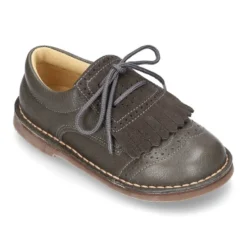 Zapatito tipo blucher con lengüeta con flecos y picados en piel combinada.
