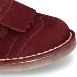 Zapatito tipo Blucher con lengüeta con flecos y picados en serraje.