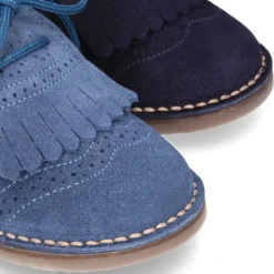 Zapatito tipo Blucher con lengüeta con flecos y picados en serraje.