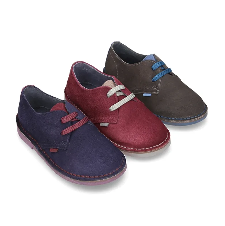 Zapatito tipo blucher con lengüeta, cordones y suela combinado en piel serraje.