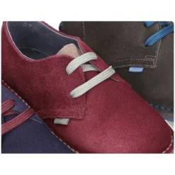 Zapatito tipo blucher con lengüeta, cordones y suela combinado en piel serraje.