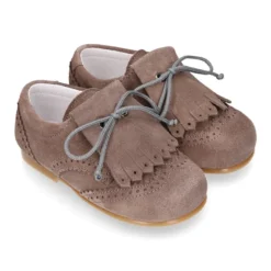 Zapatito tipo Blucher niño con lengüeta y picados en serraje.