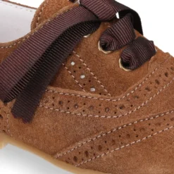 Zapatito tipo Blucher niño con lazo y picados en serraje.