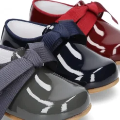 Zapatito tipo Blucher niño en piel charol con lazos.