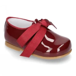 Zapatito tipo Blucher niño en piel charol con lazos.