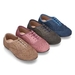 Zapato clásico tipo Blucher con lazos y picados en piel serraje.