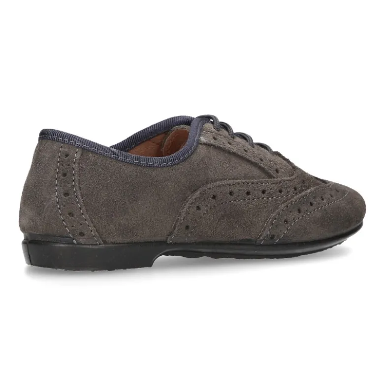 Zapato clásico tipo Blucher con lazos y picados en piel serraje.