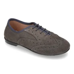 Zapato clásico tipo Blucher con lazos y picados en piel serraje.