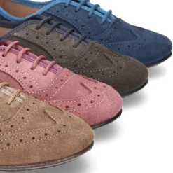 Zapato clásico tipo Blucher con lazos y picados en piel serraje.