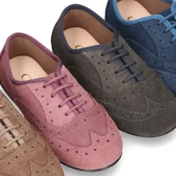 Zapato clásico tipo Blucher con lazos y picados en piel serraje.