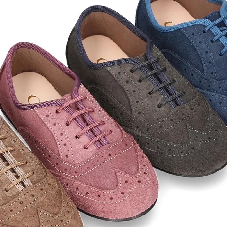 Zapato clásico tipo Blucher con lazos y picados en piel serraje.
