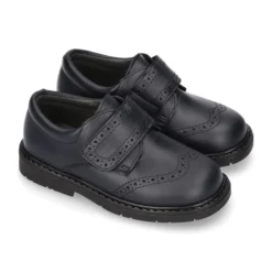 Zapato colegial niño tipo Blucher sin cordones y diseño pala vega en piel.