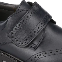 Zapato colegial niño tipo Blucher sin cordones y diseño pala vega en piel.