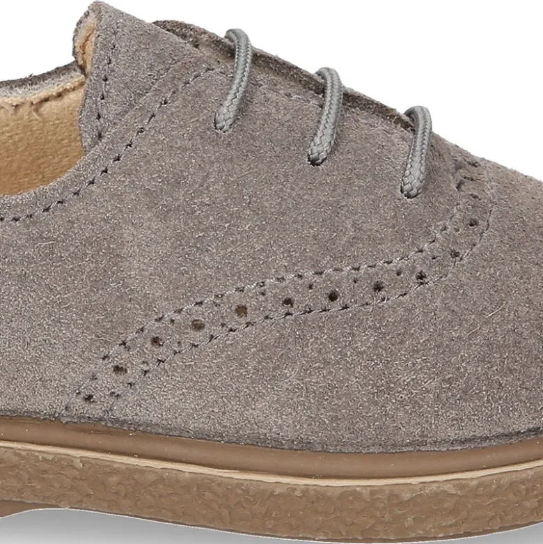 Zapato tipo BLUCHER con cordones y picados en piel serraje.