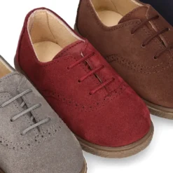 Zapato tipo BLUCHER con cordones y picados en piel serraje.
