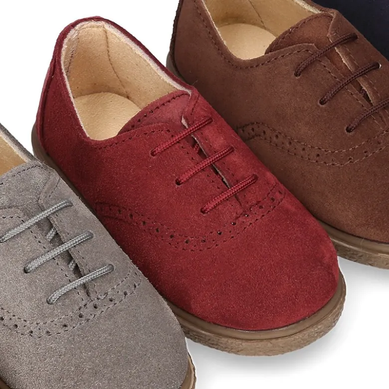 Zapato tipo BLUCHER con cordones y picados en piel serraje.