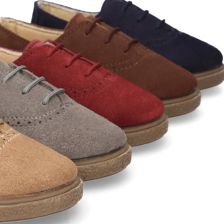 Zapato tipo BLUCHER con cordones y picados en piel serraje.