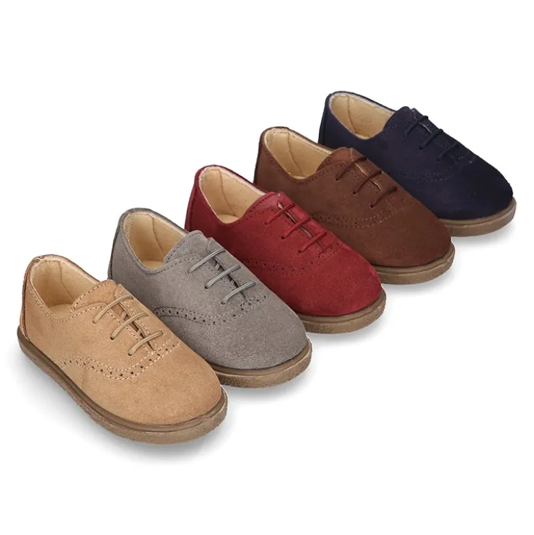 Zapato tipo BLUCHER con cordones y picados en piel serraje.